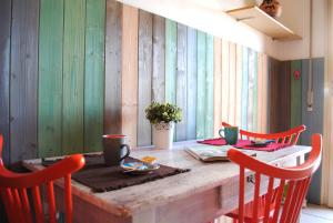 a dining room table with red chairs and a table with at Bnbook - Ferrarin Apartment in Sesto Calende