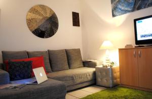 un soggiorno con divano e computer portatile. di Bnbook - Ferrarin Apartment a Sesto Calende