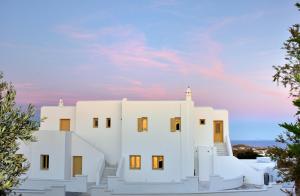 a white building with a sunset in the background at Jenny's Summer Houses in Platis Gialos