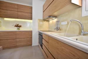a kitchen with wooden cabinets and a sink at Jenny's Summer Houses in Platis Yialos Mykonos +75 photos