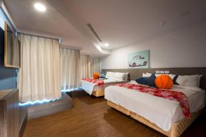 una habitación de hotel con 2 camas con bolas de naranja en Wish Hotel en Zhongli