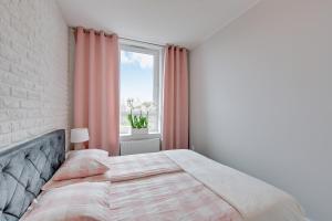 ein Schlafzimmer mit einem Bett und einem großen Fenster in der Unterkunft Apartament Mistral Gdynia in Gdynia