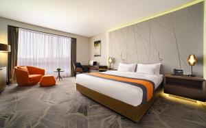 a hotel room with a large bed and a desk at Tigre de Cristal Resort & Casino Vladivostok in Artyom