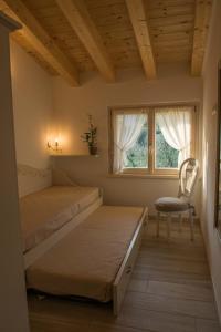 a bedroom with two beds and a chair and a window at Alle Vignole in Garda