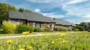a house with a field of flowers in front of it at Village Beauséjour - Rêves de mer in Le Conquet