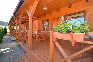 a porch of a wooden house with a potted plant at AMANDA Domki letniskowe in Darłowo