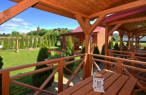 a wooden pergola with a wooden table on a patio at AMANDA Domki letniskowe in Darłowo