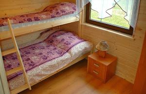 a bedroom with two bunk beds and a window at AMANDA Domki letniskowe in Darłowo