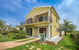 una casa gialla con balcone e cortile di Apartments Katja a Marčana