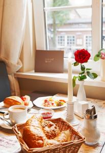 une table avec des assiettes de nourriture et une fenêtre dans l'établissement Hotel Nordwind, à Langeoog