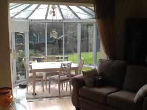 a living room with a couch and a table and chairs at Arron House in Hamilton
