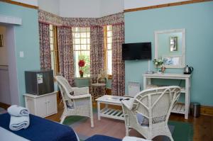 a living room with two chairs and a tv at Annies House in Cradock