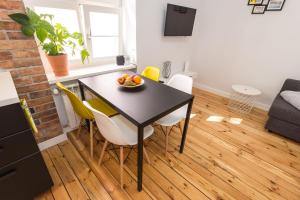 a kitchen and dining room with a table and chairs at Bliss Apartments Sydney in Poznań