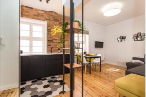 een keuken en een woonkamer met een bakstenen muur bij Bliss Apartments Sydney in Poznań