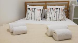 uma cama com toalhas e almofadas em Casa Mia em Lisboa