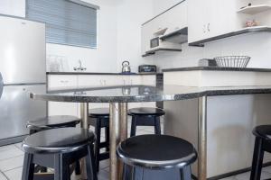 a kitchen with a counter with stools in it at Seabrook 305 Margate RSA in Margate