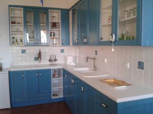 a kitchen with blue cabinets and a sink at Marvelous Sea View Eco Apt in Ammouliani