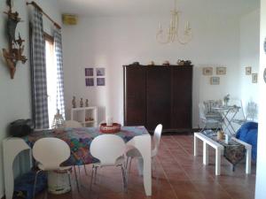 a dining room with a table and white chairs at Marvelous Sea View Eco Apt in Ammouliani