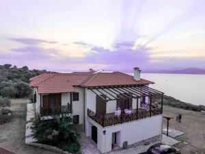 a house with a balcony next to a body of water at Marvelous Sea View Eco Apt in Ammouliani