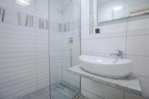 Baño blanco con lavabo y espejo en Villa Kate, en Split