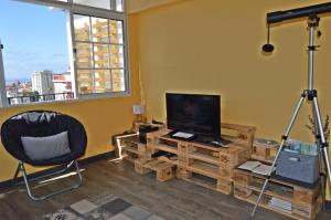 a living room with a television and a chair and a desk at Top Floor With Balcony in Funchal in Funchal