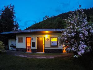 ein kleines Haus mit einem blühenden Baum davor in der Unterkunft Camp Podljubelj in Podljubelj