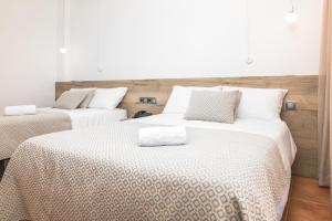 two beds with white sheets in a room at RVHotels Nieves Mar in L'Escala