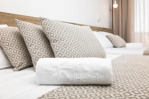 a white bed with pillows on top of it at RVHotels Nieves Mar in L'Escala