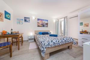 a bedroom with a bed and a desk and a table at Degrassi Square Apartments in Vrsar