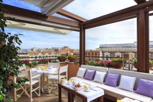 d'un balcon avec des tables et des chaises offrant une vue sur la ville. dans l'établissement Roof Suite Rome, à Rome