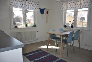 cocina con mesa, sillas y ventanas en Sjöhuset en Ellös