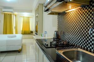 a kitchen with a sink and a counter top at Minimalist Studio Room at Grand Serpong Apartment By Travelio in Tangerang