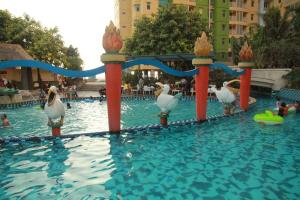 a group of birds in a pool at a resort at Minimalist Studio Room at Grand Serpong Apartment By Travelio in Tangerang