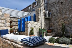 a bed sitting outside of a stone building at Kuća Babe Stane in Murter