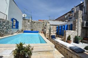 a swimming pool in front of a building at Kuća Babe Stane in Murter