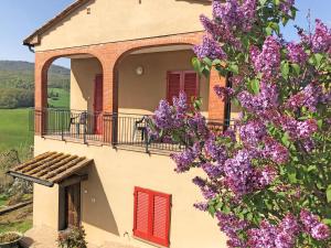 uma casa com flores roxas em frente a um edifício em Agriturismo Le Capanne em San Dalmazio