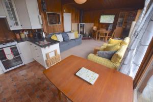 a kitchen and living room with a table and a couch at Dalriada by Loch Goil in Carrick