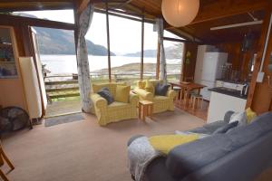a living room with couches and a view of the water at Dalriada by Loch Goil in Carrick