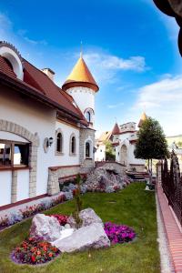 a building with a garden with flowers in the yard at Wynajem Pokoi in Krynica Zdrój