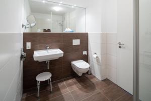 a bathroom with a sink and a toilet and a mirror at Haus KLIPPER Norderney in Norderney