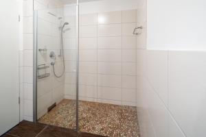 a bathroom with a shower with a glass door at Haus KLIPPER Norderney in Norderney