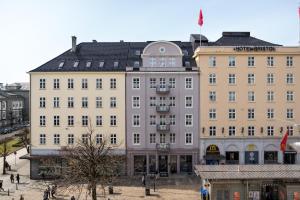 un gran edificio con gente caminando delante de él en Hotel No13 en Bergen