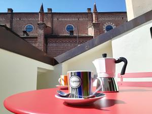 einen roten Tisch mit zwei Kaffeetassen drauf in der Unterkunft Sottoriva dream in Verona
