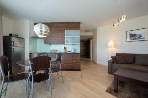 a kitchen and living room with a table and a couch at Apartamenty Apartinfo Na Klifie in Władysławowo