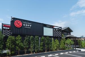 a building with a coffee sign on the side of a street at HOTEL R9 Kujukuri "ex Casual Resort COFF Ichinomiya" in Ichinomiya