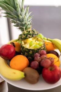 a plate of fruit with a pineapple and other fruits at Haus KLIPPER Norderney in Norderney