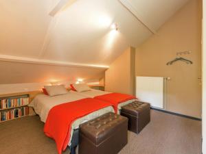 um quarto com uma cama grande e um cobertor vermelho em Beautiful holiday home in Redu with whirlpool em Redu