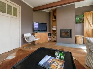 a living room with a table and a tv at Beautiful holiday home in Redu with whirlpool in Redu