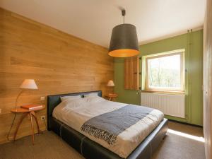 um quarto com uma cama e uma parede de madeira em Beautiful holiday home in Redu with whirlpool em Redu