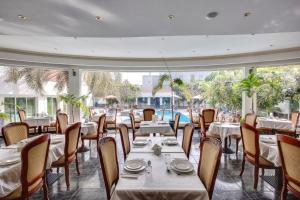 a restaurant with tables and chairs and a large window at Al Khalidiah Resort in Sharjah